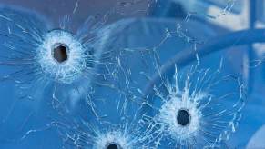 A car windshield with three bullet holes in the glass