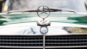 The Mercedes hood emblem on a vintage car.