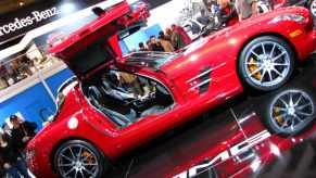 Red Mercedes gullwing SLS coupe at an auto show.