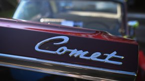 The "Comet" badge on the trunk of a Mercury Comet Caliente at a car show.