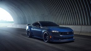 A new Ford Mustang Dark Horse drives through a tunnel.