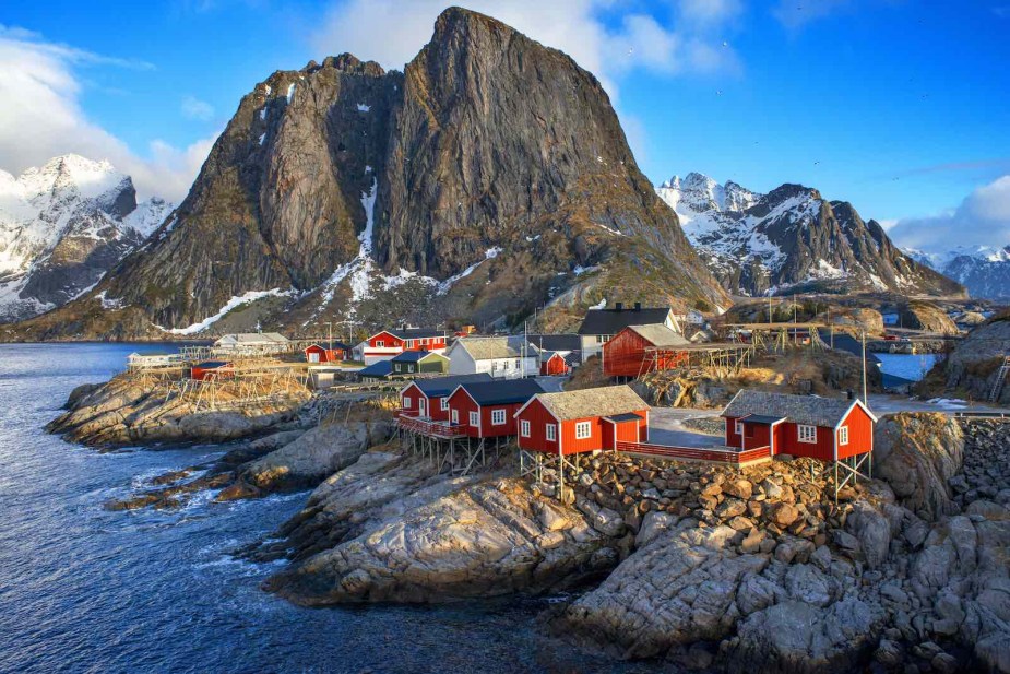 Traditional Norwegian village on the coast of the Atlantic, mountains visible in the background.