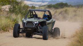 MotorBiscuit Staff Writer Erik Sherman kicks up dust and sand in Coos Bay, Oregon in a Polaris SxS.