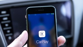 A man holding a phone while connecting Wireless Apple CarPlay