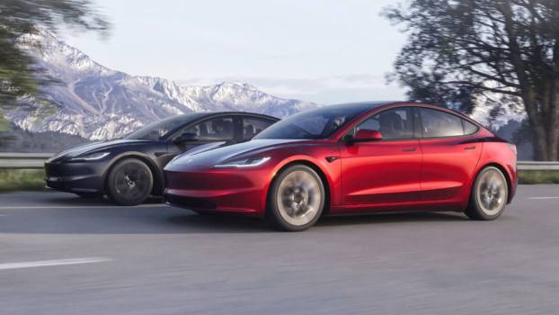 A pair of Tesla model EVs, the brand's cheapest electric cars, on the road.