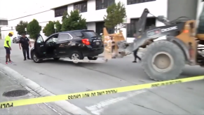 A construction working using a forklift to move an SUV