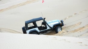 A Jeep Wrangler TJ in the sand after a jump.