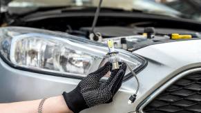 A driver takes care of a fix-it ticket by replacing an LED headlamp bulb.