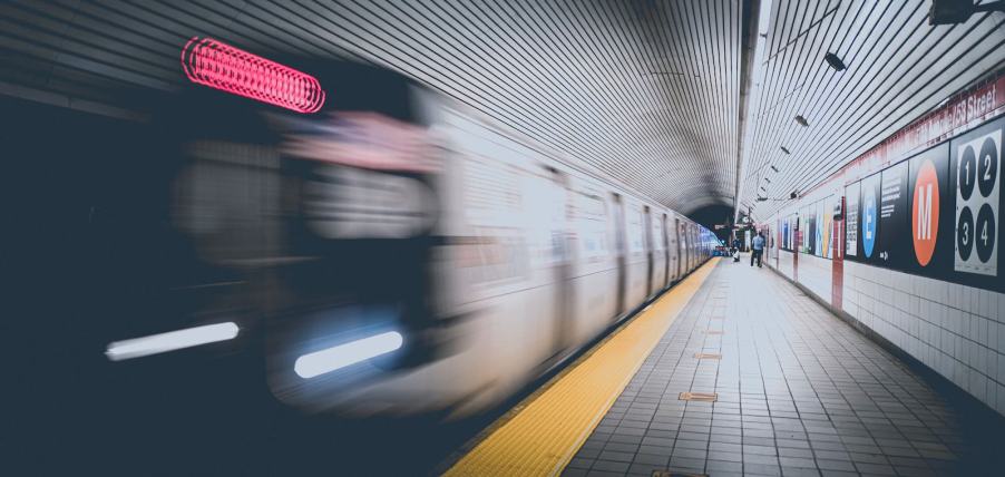 Train blurring by the platform in a New York City subway