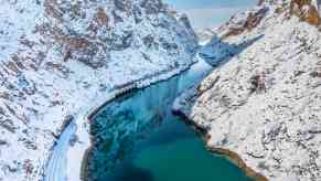 The eastern orient express navigates a narrow mountain valley in Turkey, alongside a river.