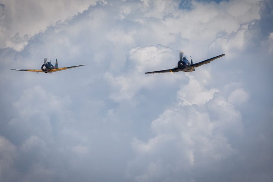 WWII airplanes fly next to one another in a color image.