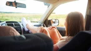 A passenger with her feet on the car dashboard