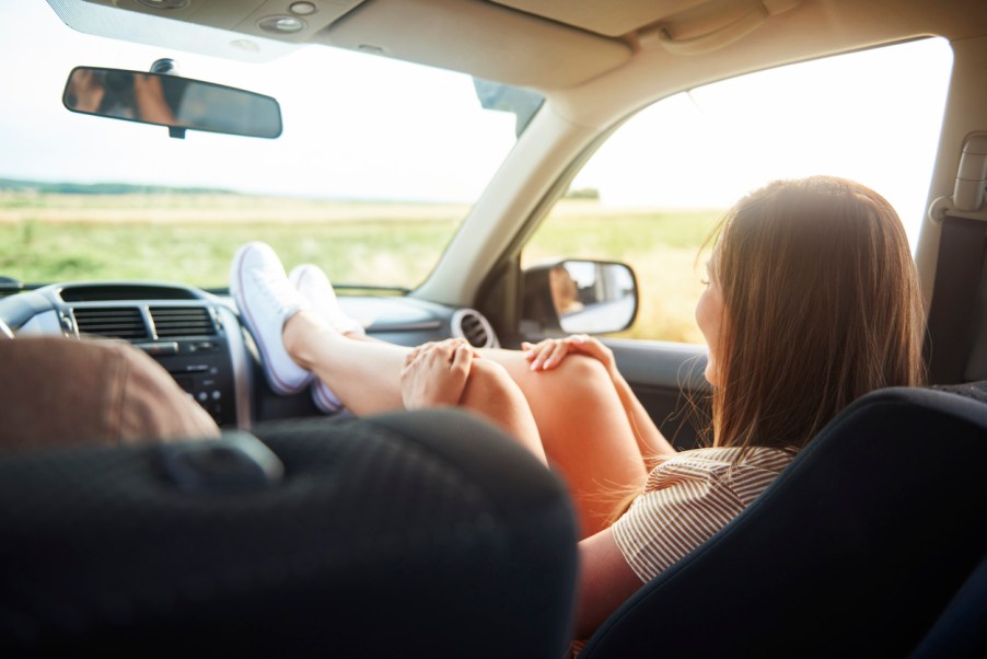 A passenger with her feet on the car dashboard