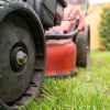 Riding lawn mower in close view of left front wheel and side