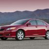 A red 6th gen Toyota Camry, which ran from 2007 to 2009, parked in left front angle view at dusk