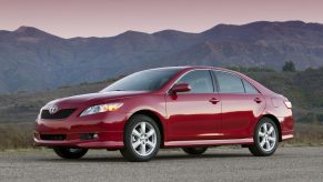 A red 6th gen Toyota Camry, which ran from 2007 to 2009, parked in left front angle view at dusk