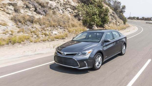 A used Toyota Avalon drives on a mountain road.