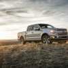 A 2018 Ford F-150 parked in a field at dusk in right front profile view right of frame