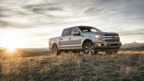 A 2018 Ford F-150 parked in a field at dusk in right front profile view right of frame