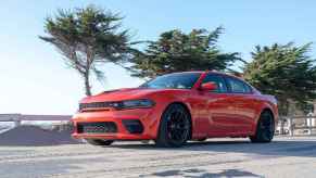 A red 2022 Dodge Charger Scat Pack Widebody driving near beach in left side angle view