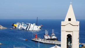 The shipwreck of the Costa Concordia off the coast of Italy, a church steeple in the foreground.