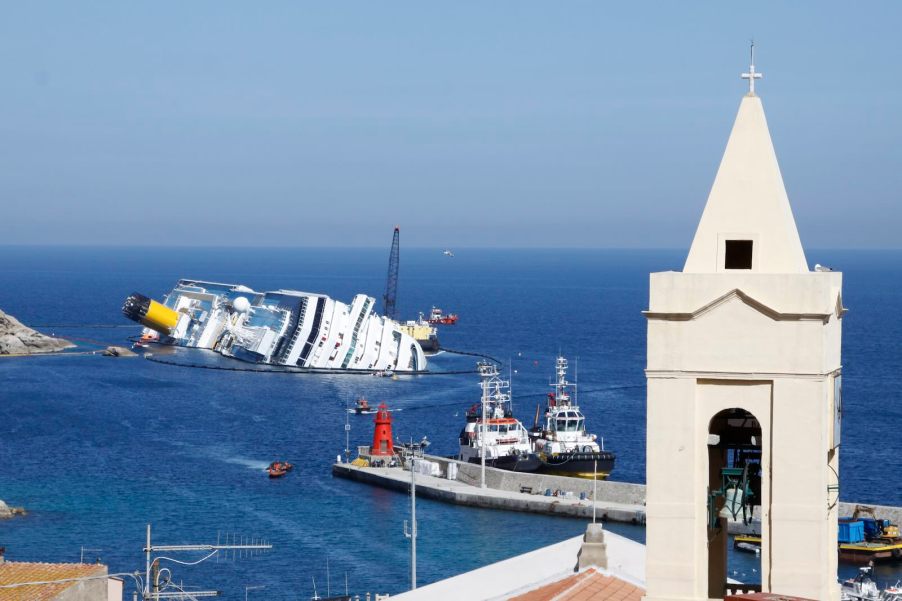 The shipwreck of the Costa Concordia off the coast of Italy, a church steeple in the foreground.