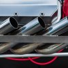 A set of open header exhaust pipes on a custom car build.