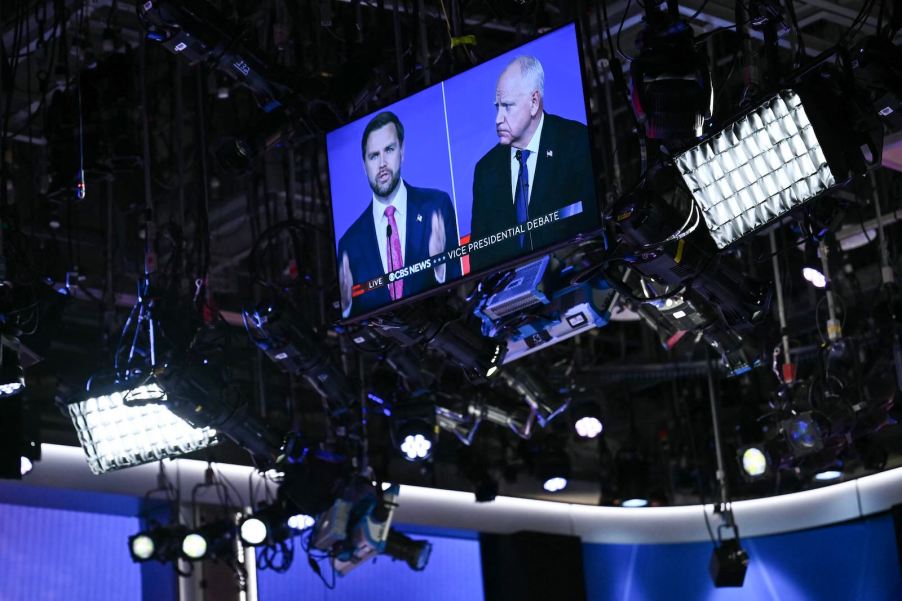 A monitor on the U.S. 2024 Vice Presidential debate stage shows both candidates, Governor Tim Walz and Senator J.D. Vance.