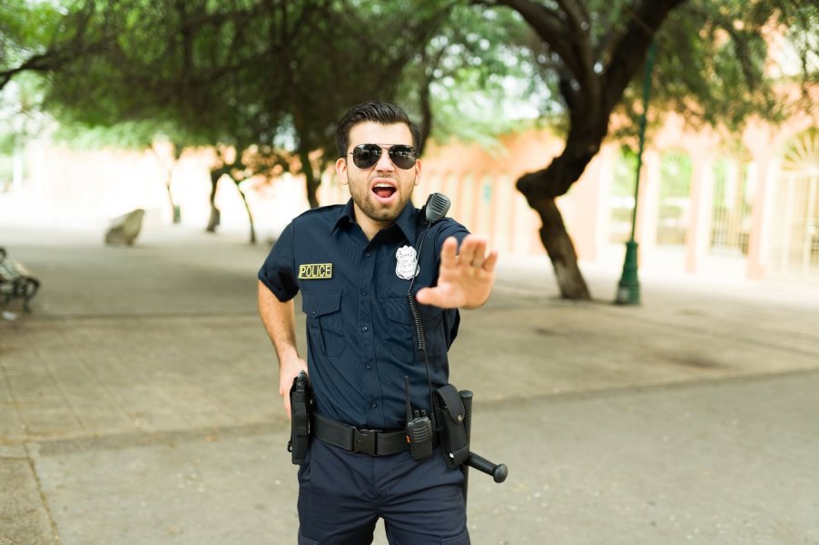 Police officer stopping a car to commandeer it.