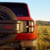 Closeup of the Scout logo on a 2027 electric SUV vehicle parked in a field