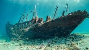 Old shipwreck at the bottom of a brilliant, blue ocean.