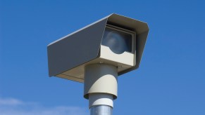 Automatic camera photographs speeders to send tickets, a blue sky in the background.