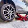 A car on a jack stand showing the wheel's lug nut set in close view