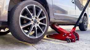 A car on a jack stand showing the wheel's lug nut set in close view