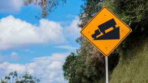 A freeway sign of a semi-truck travelling down a steep incline