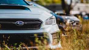 A grey Subaru WRX parked outside in close view of left front end