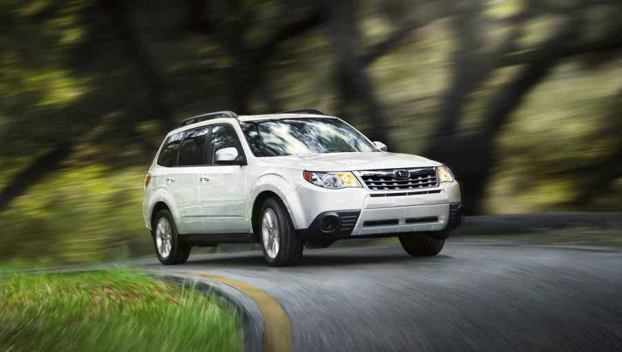 A white 2012 Subaru Forester driving in right front angle view