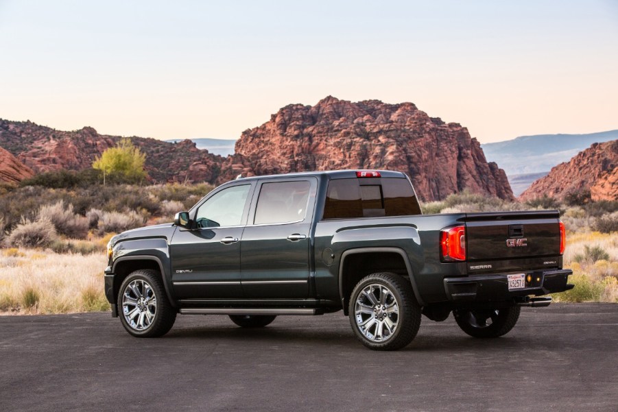 2018 GMC Sierra Denali parked in left rear angle view in scraggy clay mountainous setting