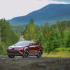 A red 2018 Toyota RAV4 parked on a road in the wilderness in left front angle view