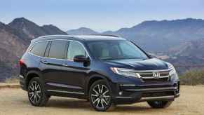 A dark blue 2019 Honda Pilot Elite parked in right front angle view in front of mountain range