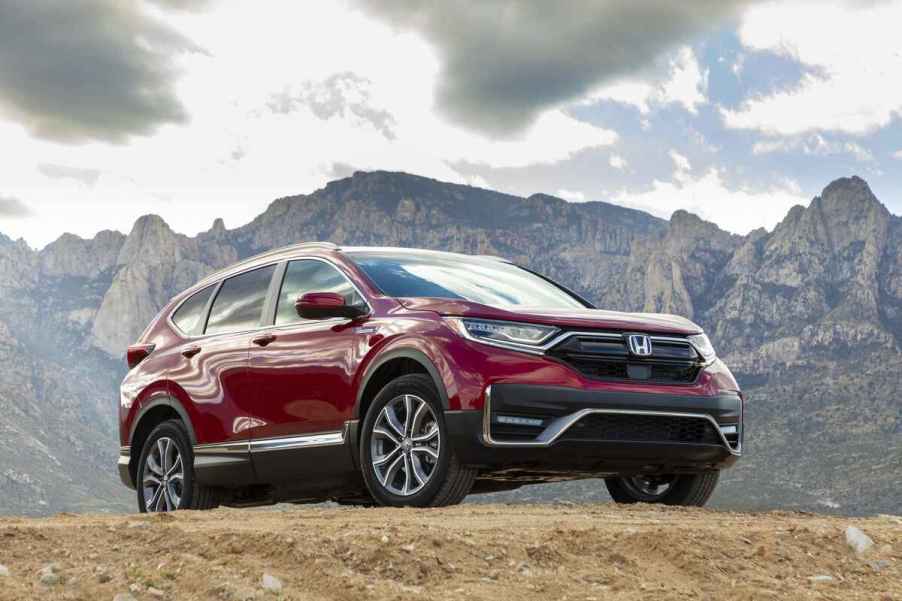 A dark red 2020 Honda CR-V Hybrid parked on a grassy mountainous hilltop