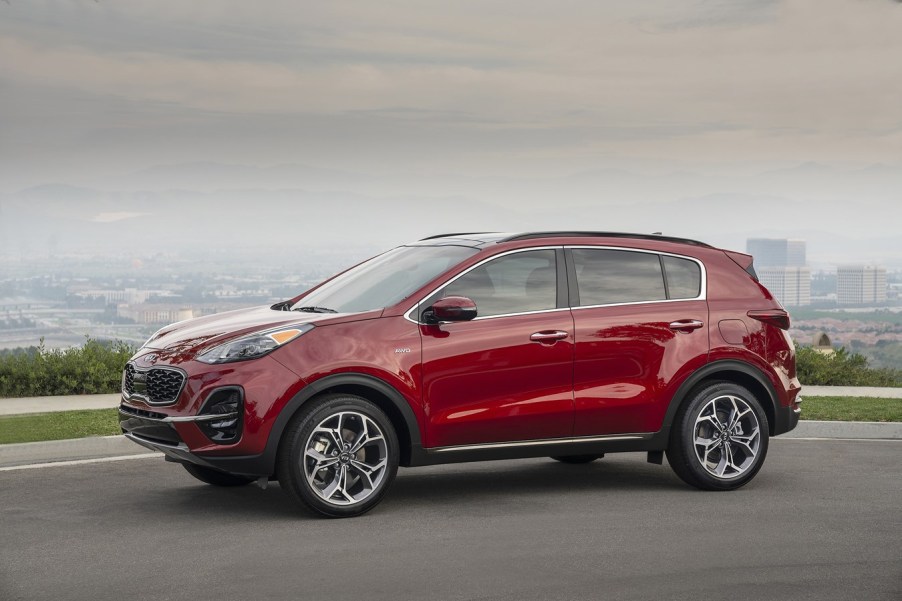 A red 2020 Kia Sportage parked on mountainous landscape in full left profile view