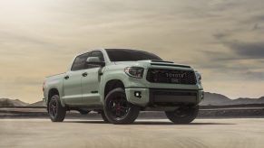 A matte light grey/green colored 2021 Toyota Tundra TRD Pro pickup truck pared in a desert environment in right front angle view