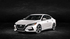 A white 2023 Nissan Sentra four-door sedan parked in left front angle view with a black background