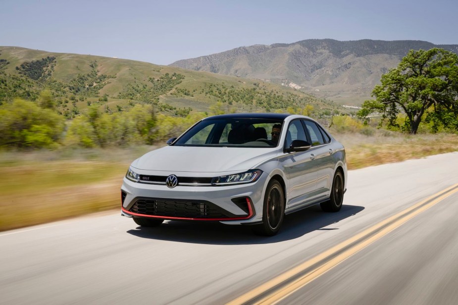 Gray Volkswagen Jetta GLI sports sedan driving down a country road