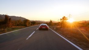 A 992 Porsche 911, one of the fastest cars on the modern market, heads down the road.