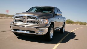 A driver in a fourth-generation Dodge RAM pickup truck on the road.