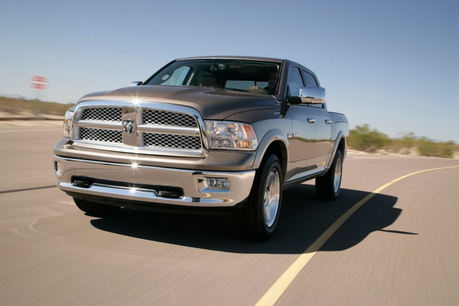 A driver in a fourth-generation Dodge RAM pickup truck on the road.