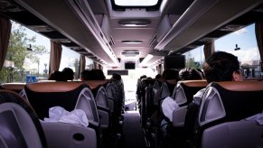 Passenger on a dutch tour bus look at a sunroof.