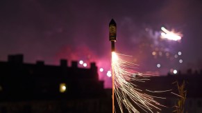 Fireworks rocket launching into a purple night sky